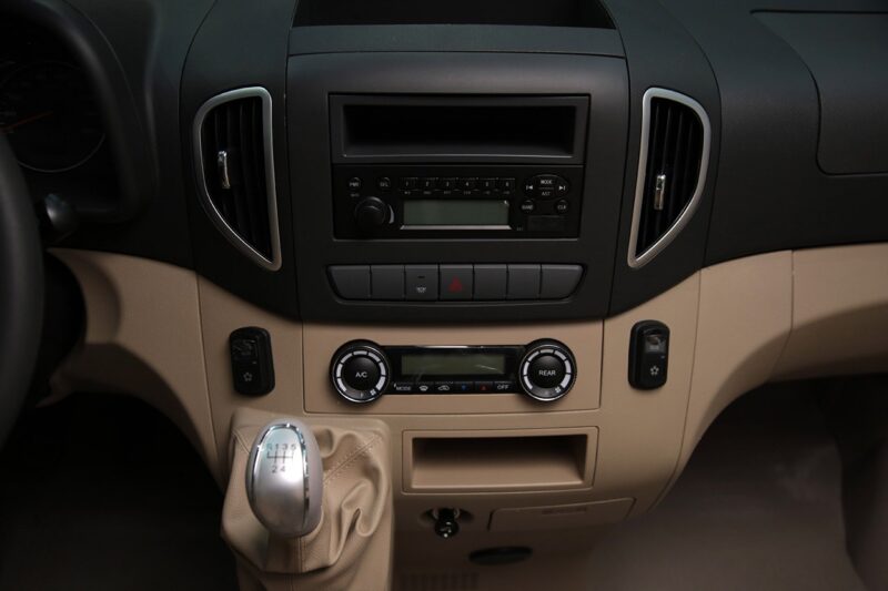 Центральная консоль JAC Sunray с магнитолой, элементами управления климатом и рычагом коробки передач.